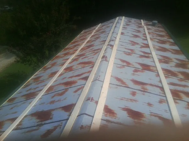 Rusted metal roof panels with new wood purlins before replacement — Storm Damage Roof Repair in Islandton by Roofing Brothers