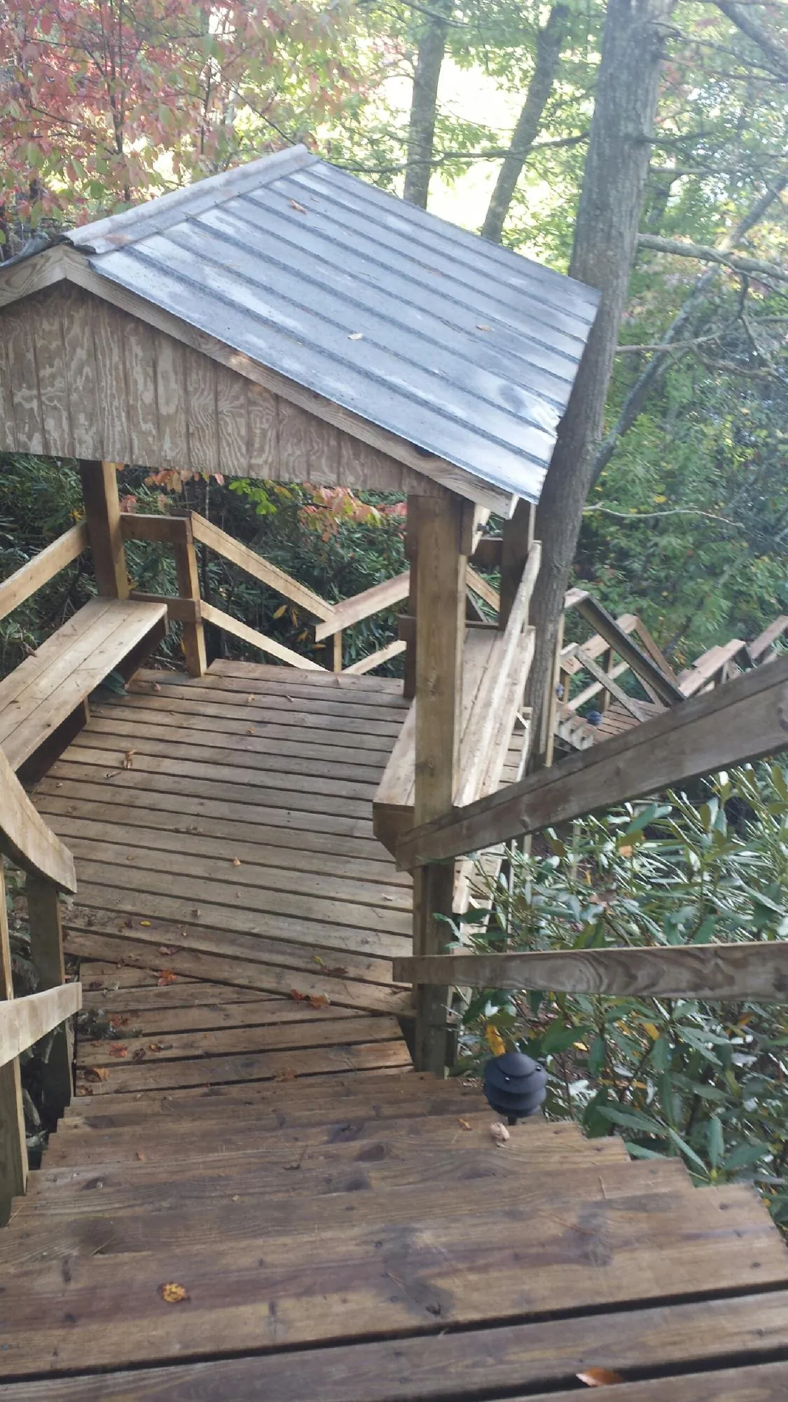 Metal roofed shelter over wooden steps on a wooded walkway — Skylight Repair & Installation work by our crew in Islandton