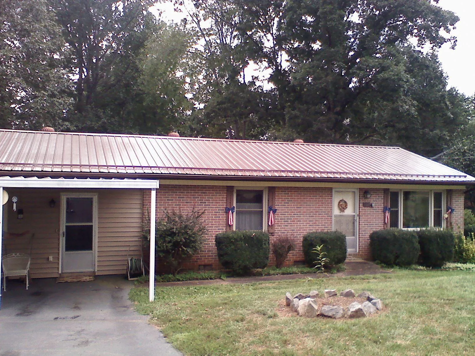 Bronze metal roof and carport on a brick ranch home — Roof Repair work by our crew in Islandton